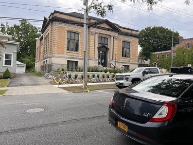 Library building with parked cars and plants