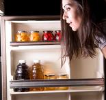 alt="woman looking inside her refrigerator"