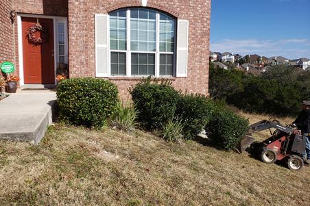 A landscaping job by wilson landscape in San Antonio texas of a circular rumblestone paver patio design with a beautiful stone fire pit in the middle and outdoor seating with river rock bordering