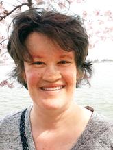 Outdoor head-shot of Rebecca, smiling, looking at the camera